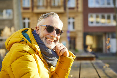 Porträt eines lächelnden reifen Mannes mit Sonnenbrille in der Stadt, lizenzfreies Stockfoto