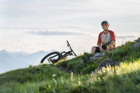 Mountainbiker im Abendlicht in Graubünden, Schweiz, lizenzfreies Stockfoto