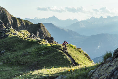 Mountainbiker auf einem Weg auf einem Bergrücken, Graubünden, Schweiz - HBIF00011