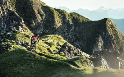 Mountainbiker auf einem Weg auf einem Bergrücken, Graubünden, Schweiz - HBIF00012