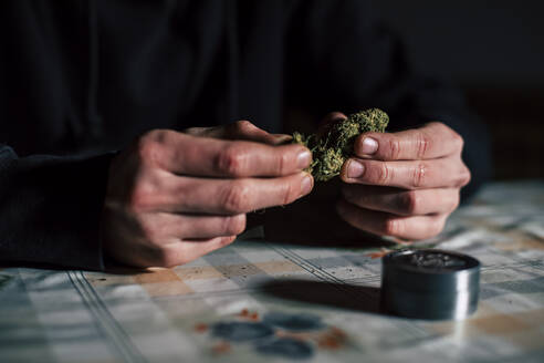 Nahaufnahme der Hände eines Mannes, der einen Marihuana-Joint vorbereitet - ACPF00674