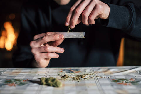 Nahaufnahme der Hände eines Mannes, der einen Marihuana-Joint vorbereitet, lizenzfreies Stockfoto