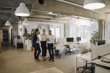 Business team having a meeting in office sharing a tablet - KNSF07539