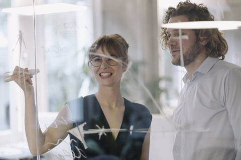 Businessman and businesswoman working on a project in office stock photo