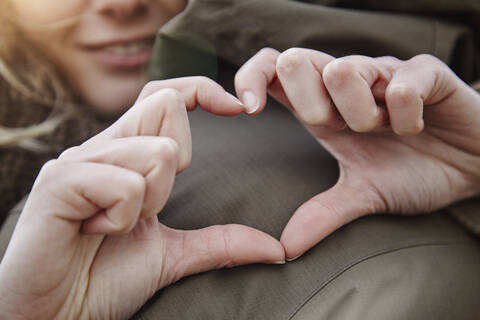 Hands of young woman forming heart, close-up stock photo