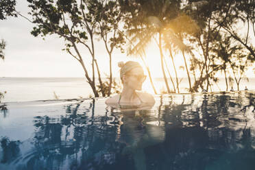 Frau im Infinity-Pool bei Sonnenuntergang, Nai Thon Beach, Phuket, Thailand - CHPF00618