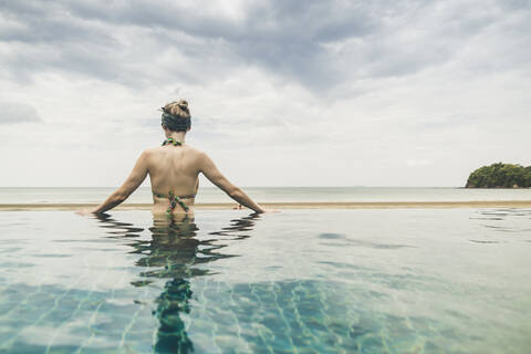 Rückansicht einer Frau im Infinity-Pool, Koh Lanta, Thailand, lizenzfreies Stockfoto