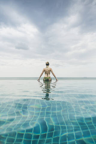 Rückansicht einer Frau im Infinity-Pool, Koh Lanta, Thailand, lizenzfreies Stockfoto