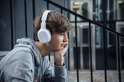 Portrait of teenager with headphones, thoughtful - ANHF00177