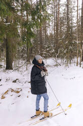 Lächelnde Frau auf Skiern im Winterwald - KNTF04181