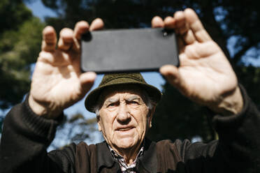 Alter Mann fotografiert mit seinem Smartphone - JRFF04110