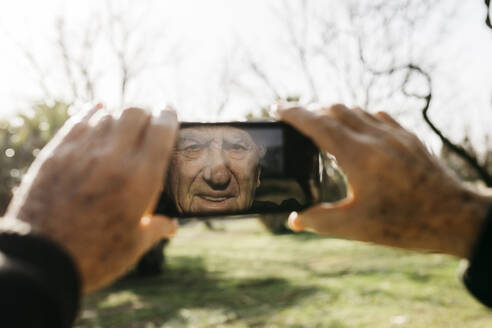 Alter Mann fotografiert mit seinem Smartphone - JRFF04112