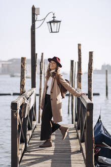 Glückliche junge Frau am Wasser in Venedig, Italien - MAUF03259