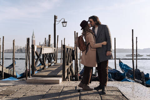 Junges Paar küsst sich am Wasser in Venedig, Italien, lizenzfreies Stockfoto