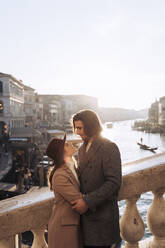 Affectionate young couple on a bridge in the city of Venice, Italy - MAUF03289