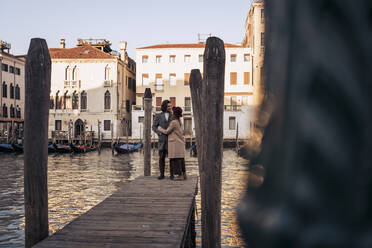Junges Paar auf einem Steg am Canal Grande in Venedig, Italien - MAUF03292