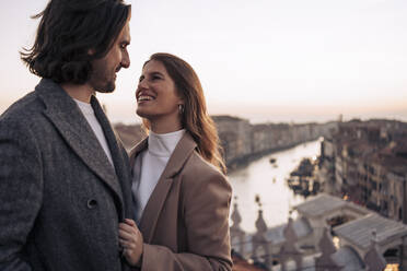 Verliebtes junges Paar auf einem Balkon über der Stadt Venedig, Italien - MAUF03304