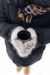 Woman's hands holding thermo mug outdoors - KNTF04199