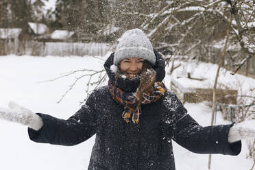 Porträt einer Frau, die den Schneefall genießt - KNTF04207