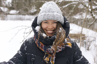 Porträt einer Frau, die den Schneefall genießt - KNTF04208