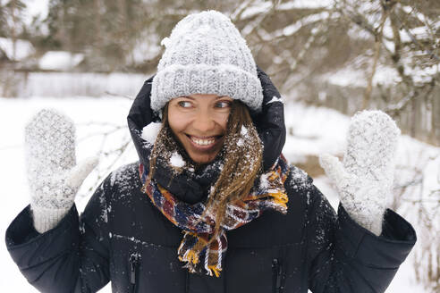 Porträt einer Frau, die den Schneefall genießt - KNTF04209