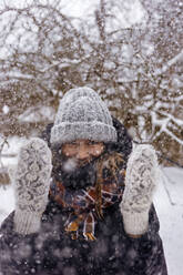 Porträt einer Frau, die den Schneefall genießt - KNTF04210