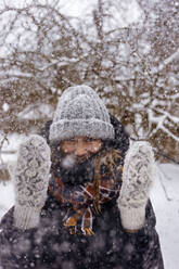 Portrait of woman enjoying snowfall - KNTF04210