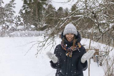 Portrait of woman enjoying snowfall - KNTF04211