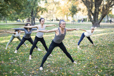 Eine Gruppe von Frauen praktiziert Yoga im Park - JOHF07531