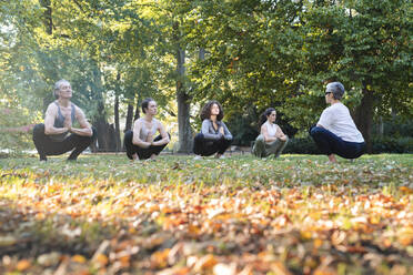 Eine Gruppe von Frauen praktiziert Yoga im Park - JOHF07532