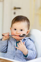 Baby girl with spoon in her mouth - JOHF07591