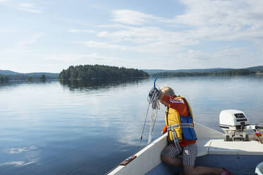 Boy pulling net out of water - JOHF07642