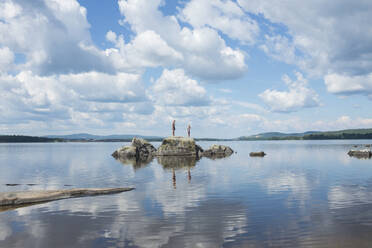 Zwei Menschen stehen auf einem Felsen im See - JOHF07646