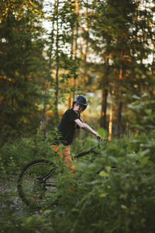 Junge fährt Fahrrad im Wald - JOHF07673