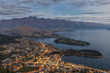 Neuseeland, Otago, Queenstown, Stadt am Ufer des Lake Wakatipu in der Abenddämmerung mit Bergen im Hintergrund - FOF11809