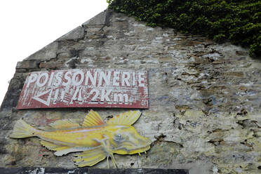 Frankreich, Bretagne, Audierne, Handgemaltes Fischladenschild mit Fischen an alter Hauswand - GISF00508