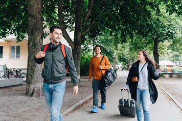 Junge Freunde gehen auf der Straße mit Gepäck in der Stadt - MASF16434