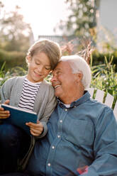 Smiling grandfather and grandson using digital tablet in backyard - MASF16495