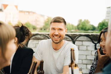 Porträt eines glücklichen Mannes, der mit Freunden zusammensitzt und sich bei einem geselligen Beisammensein amüsiert - MASF16511