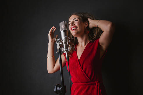 Porträt einer Sängerin mit Mikrofon, im roten Kleid - LJF01232