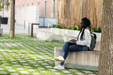 Studentin mit Laptop auf einer Bank - VABF02587