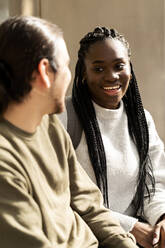 Portrait of young woman smiling at man outdoors - VABF02598