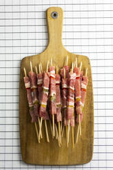 Raw meat skewers on cutting board - GIOF07951