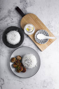 Teller mit Hühnerfleischbällchen mit Reis und Glas mit Joghurtsauce - GIOF07965