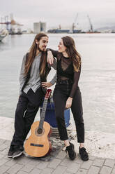 Junges Paar mit einer Gitarre am Hafen - LJF01253