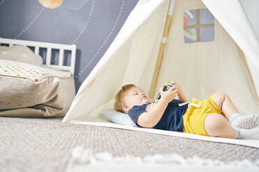 Toddler playing inside teepee - CUF54670