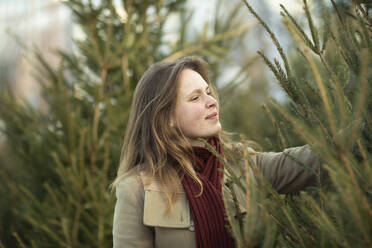 Woman shopping for Christmas tree, Christmas Market, Freiburg, Deutschland - CUF54692