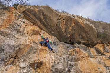 Man climbing at rock face - DLTSF00451
