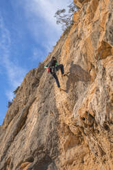 Mann klettert an Felswand - DLTSF00452