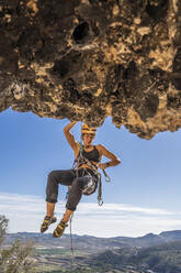 Female climber abseiling from rock face - DLTSF00468